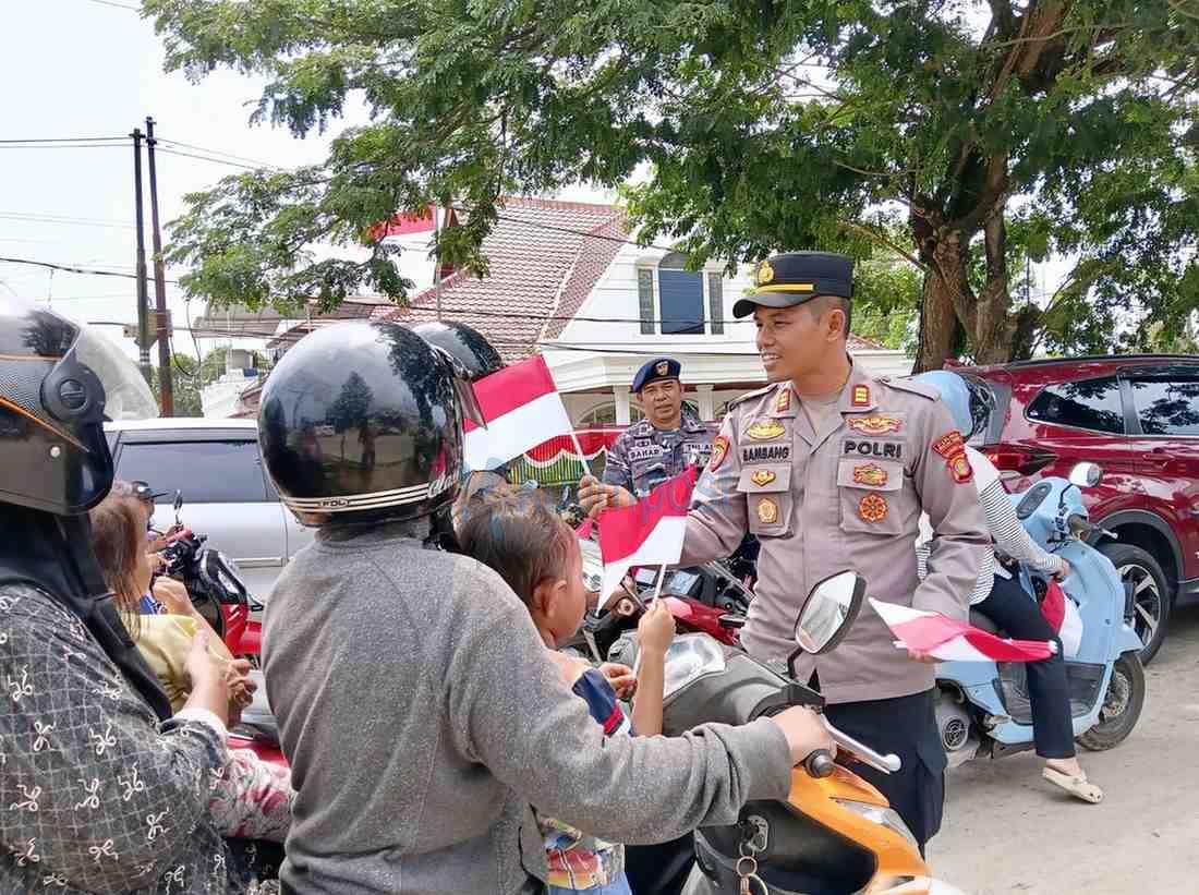 Jelang HUT RI ke-81, Polsek Sangatta Utara Turun Bagikan Bendera Merah Putih ke Warga