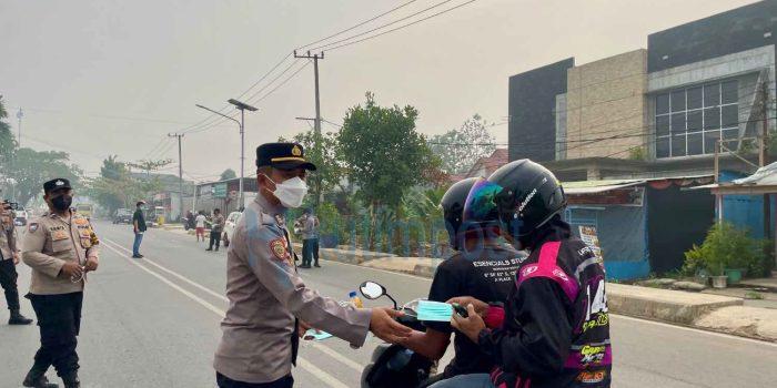 Asap Karhutla Selimuti Sangatta, Polsek Sangatta Utara Bagikan Masker ke Warga
